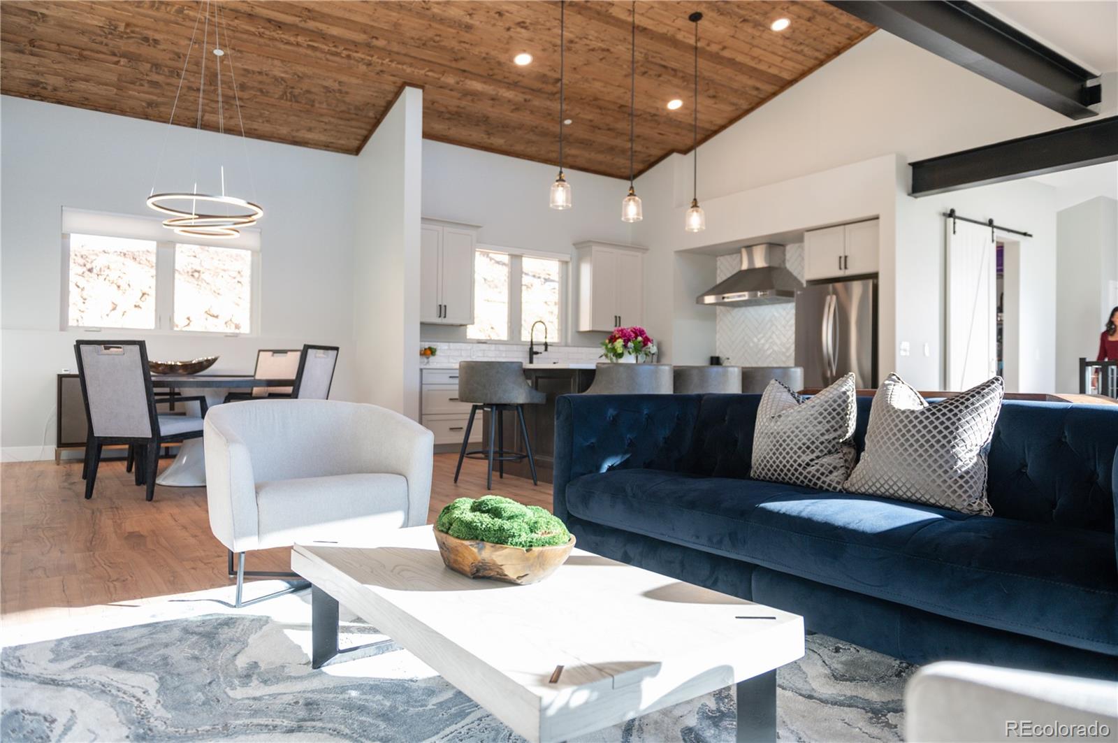 7231 Timber Trail Road Evergreen, CO 80439 - Photo 4 of 34 a living room with couches chairs and kitchen view with wooden floor