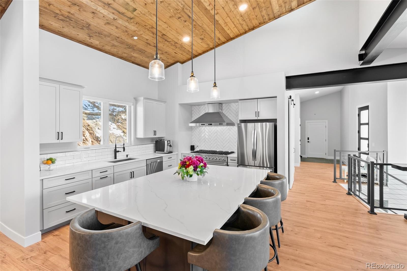 7231 Timber Trail Road Evergreen, CO 80439 - Photo 5 of 34 a kitchen with stainless steel appliances kitchen island granite countertop a table chairs and a refrigerator