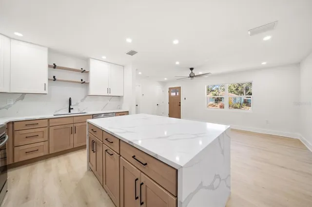 a kitchen with granite countertop a stove sink and refrigerator