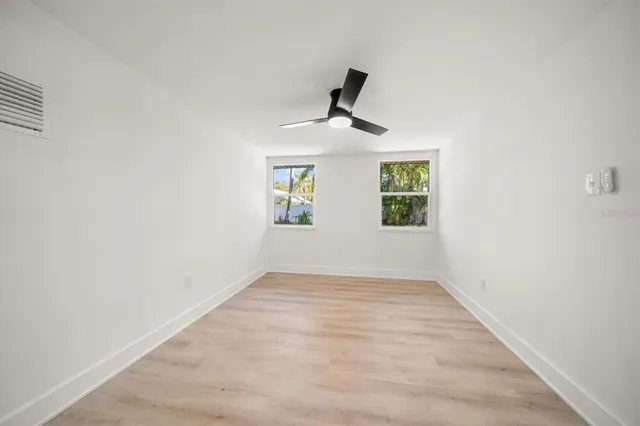 an empty room with a window and a fan