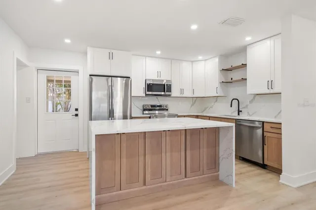 a kitchen with stainless steel appliances granite countertop a refrigerator sink and cabinets