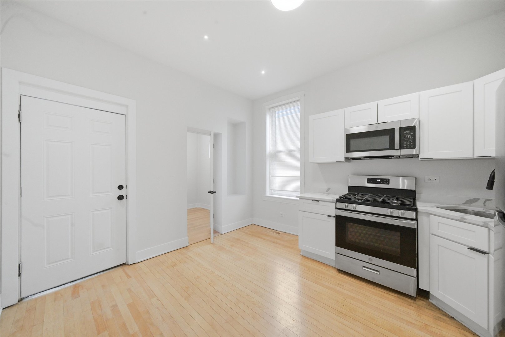 2345 West 23rd Place, Unit 3 Chicago, IL 60608 - Photo 8 of 13 a kitchen with a stove a microwave and window