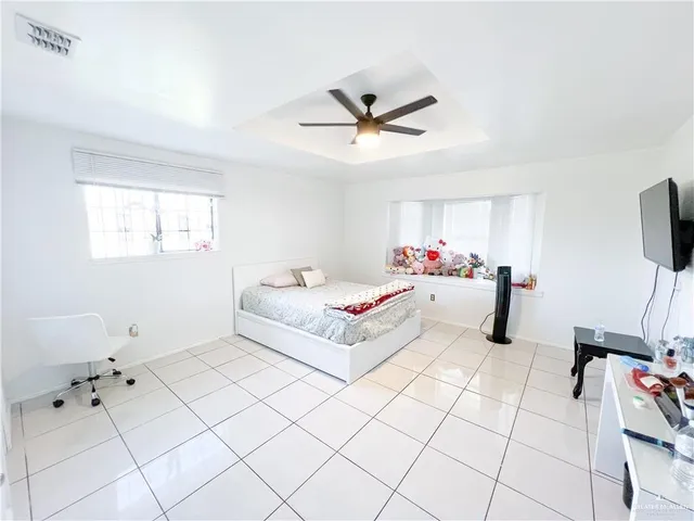 a bedroom with a bed mirror and window