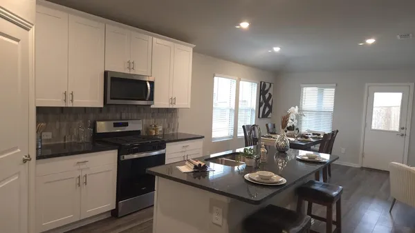 a kitchen with appliances a table and chairs in it