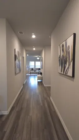 a view of a hallway with wooden floor and a workspace