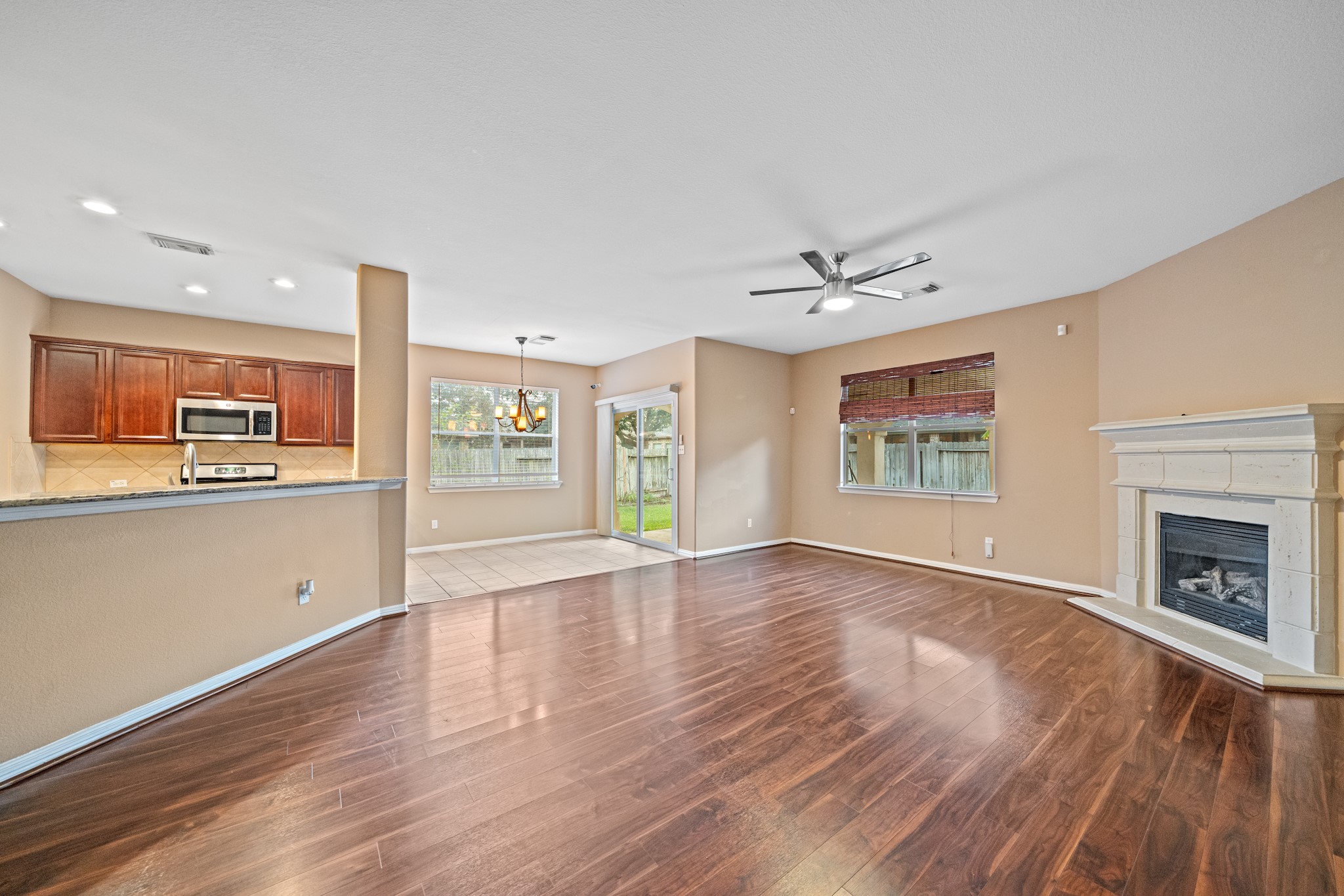 8711 Preston Field Lane Houston, TX 77095 - Photo 14 of 41 a view of an empty room with a kitchen and wooden floor