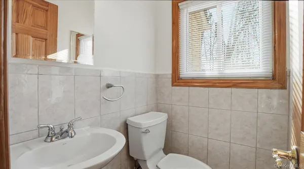 a bathroom with a sink a toilet and mirror
