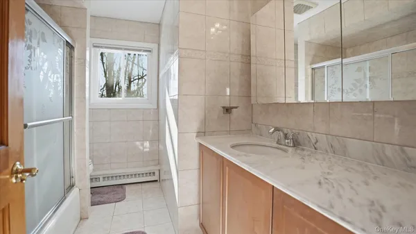 a bathroom with a granite countertop sink a mirror and a shower
