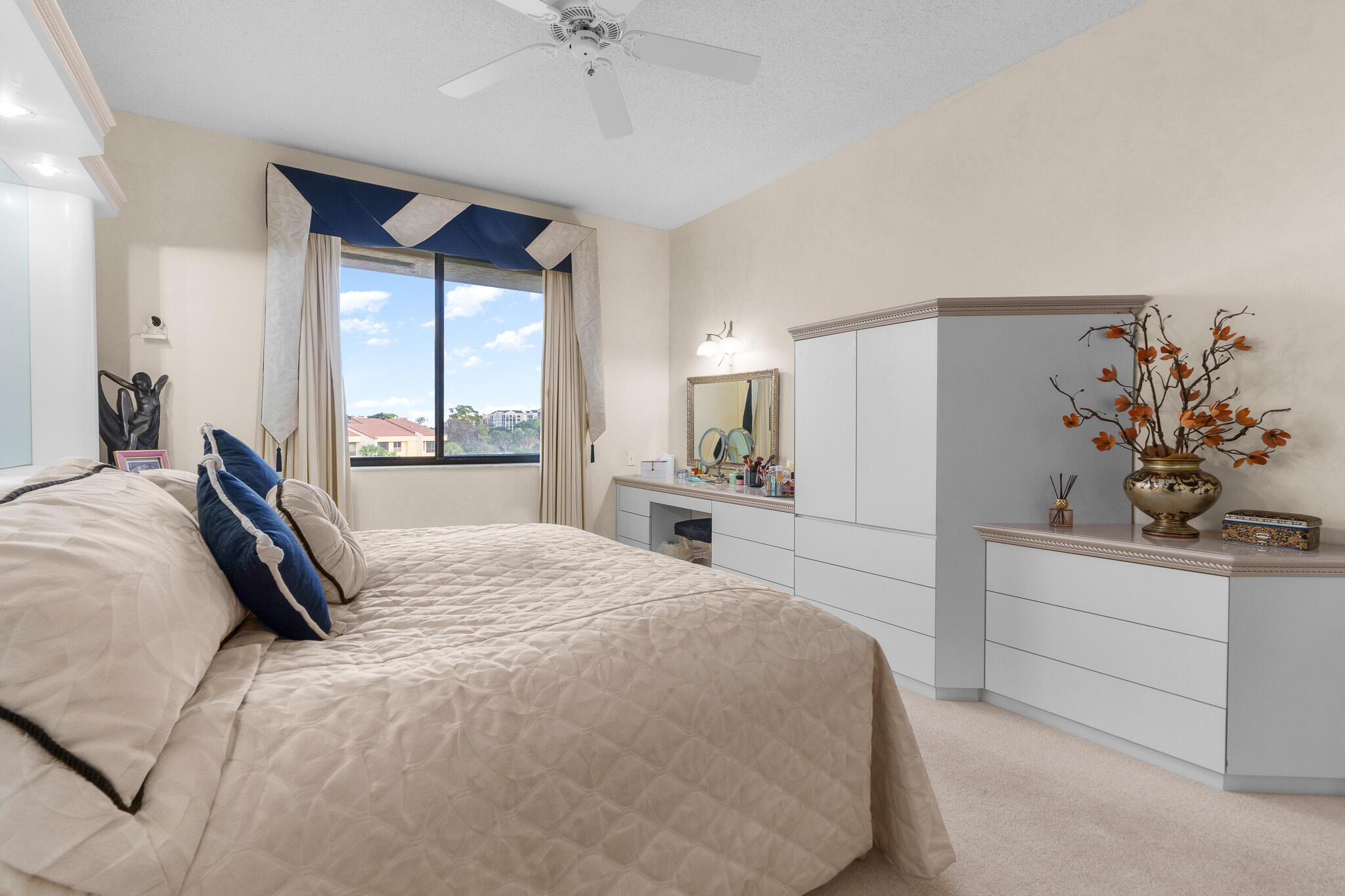 7546 La Paz Boulevard, Unit 405 Boca Raton, FL 33433 - Photo 16 of 43 a bedroom with a large bed and a chandelier