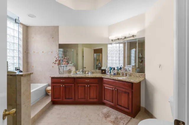 a spacious bathroom with a granite countertop double vanity and mirror