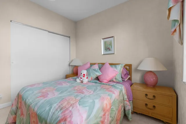 a bedroom with a bed and a lamp on dresser