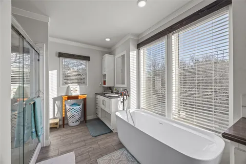 a bathroom with sink a bathtub and next to a window