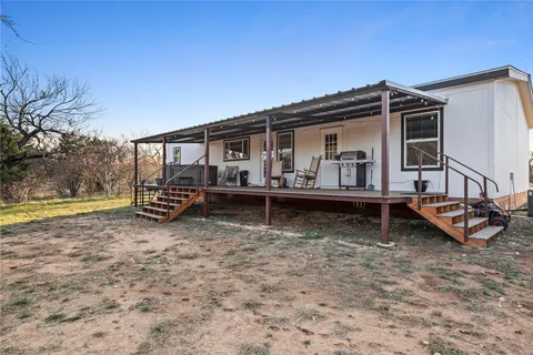 a kitchen with stainless steel appliances granite countertop a stove top oven a refrigerator a dining table and chairs with wooden floor