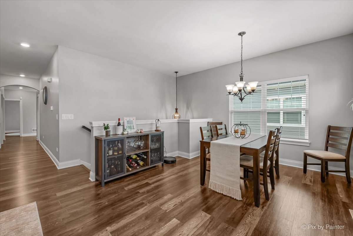745 Harper Avenue Cary, IL 60013 - Photo 12 of 32 a view of a dining room and livingroom with furniture wooden floor a chandelier