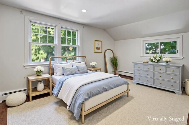a bedroom with a bed and a dresser next to a window