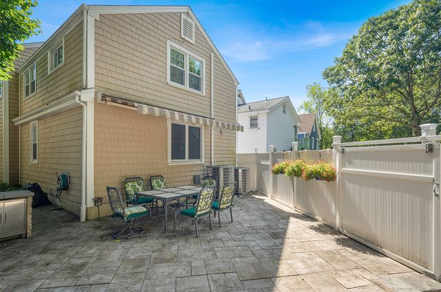 a view of a patio with table and chairs and a barbeque