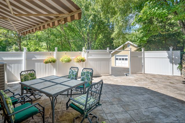a view of a patio with table and chairs with wooden fence and plants