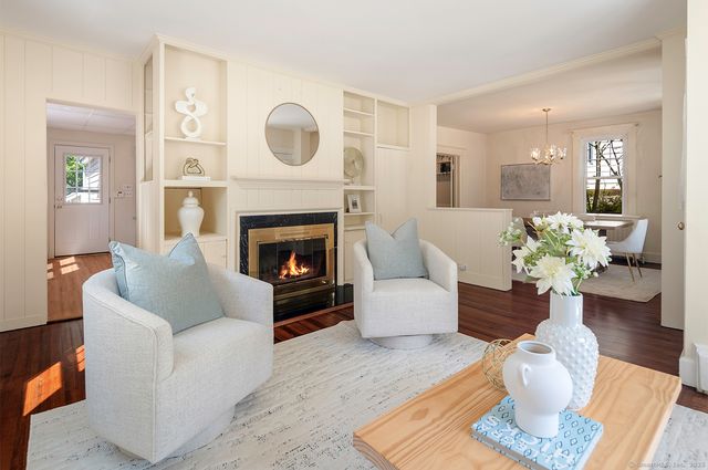 a living room with furniture a fireplace and a chandelier