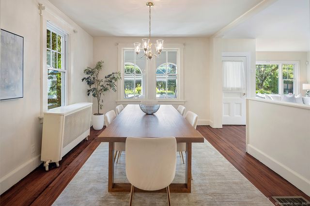 a view of a dining room with furniture a chandelier and wooden floor