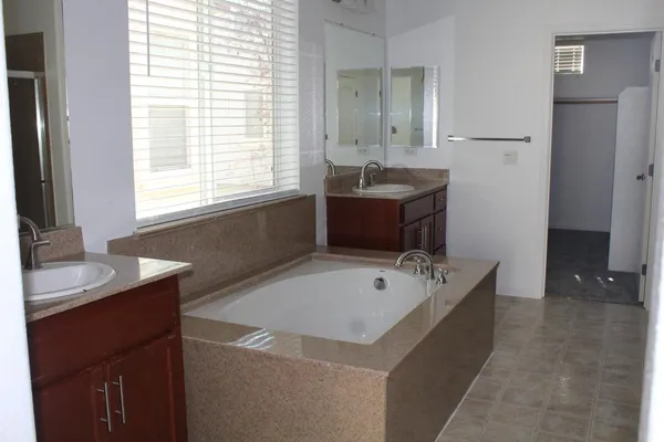 a bathroom with a tub sink and mirror