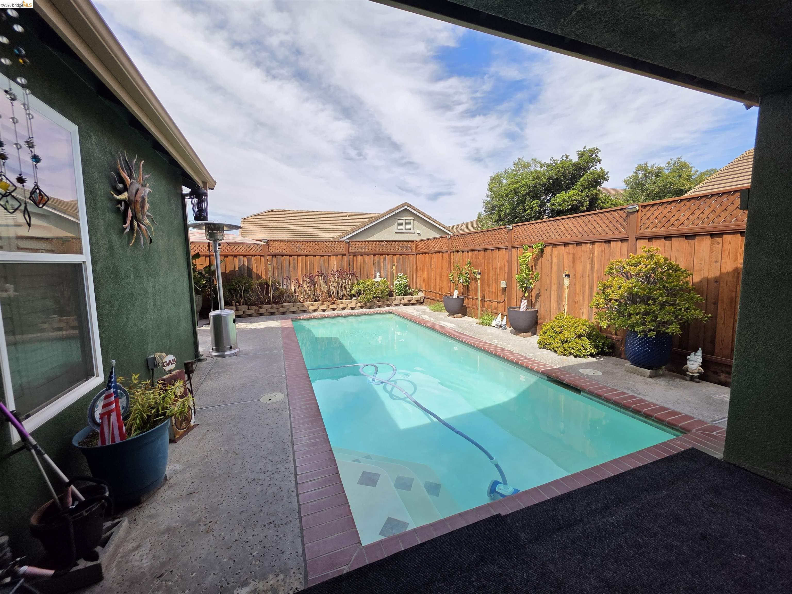 2607 Glow Road Riverbank, CA 95367 - Photo 34 of 42 Rectangular swimming pool with brick coping, concrete decking, and wood fencing