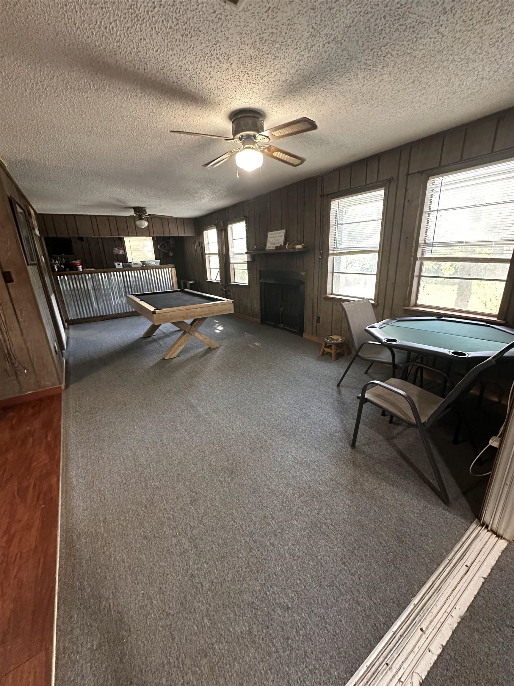 481 Chisholm Lake Camp Road Ripley, TN 38063 - Photo 10 of 12 Spacious room featuring paneled walls, a built-in fireplace, and multiple windows