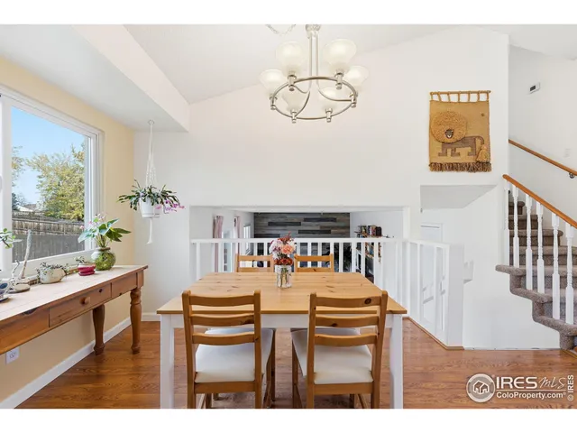 a view of a dining room with furniture a chandelier and wooden floor