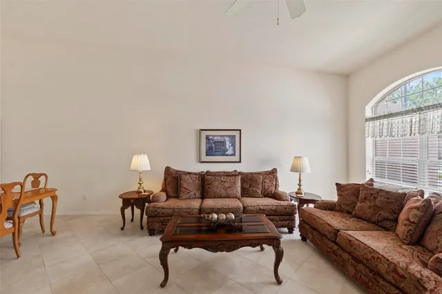 a living room with furniture a flat screen tv and a large window