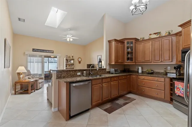 a kitchen with stainless steel appliances granite countertop a sink a stove and a refrigerator