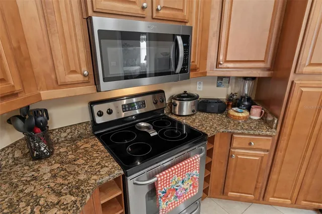 a kitchen with stainless steel appliances granite countertop a sink refrigerator and cabinets