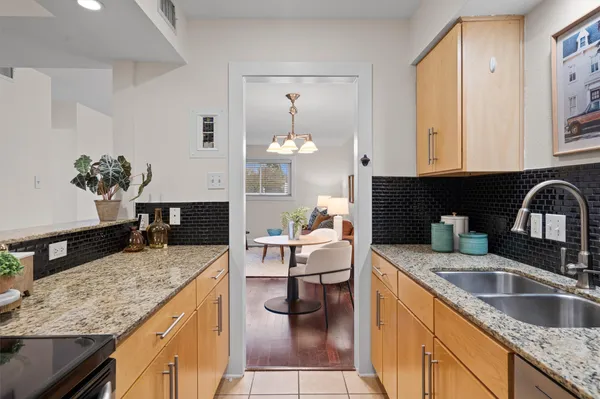 a kitchen with granite countertop a sink dishwasher stove and cabinets