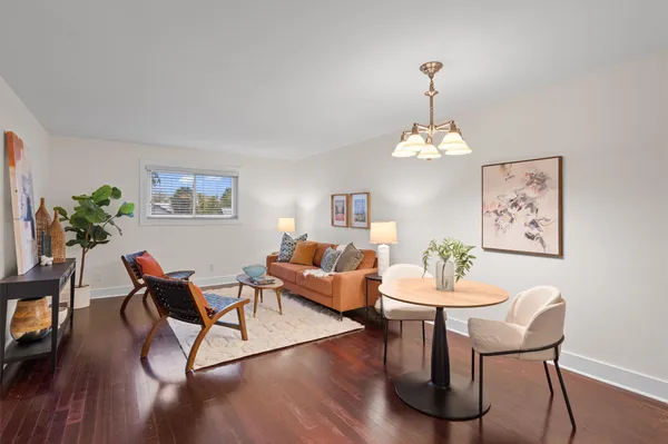 a dining room with furniture potted plants and wooden floor