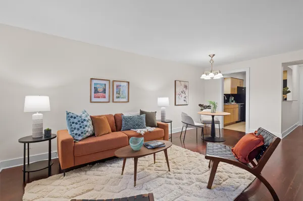 a living room with furniture a lamp and a view of kitchen