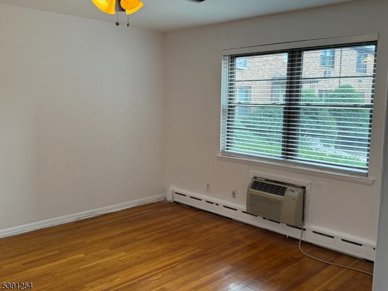 799 Mountain Avenue, Unit D Springfield, NJ 07081 - Photo 12 of 16 an empty room with wooden floor and windows