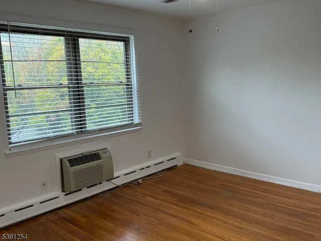 a view of a room with wooden floor and a window