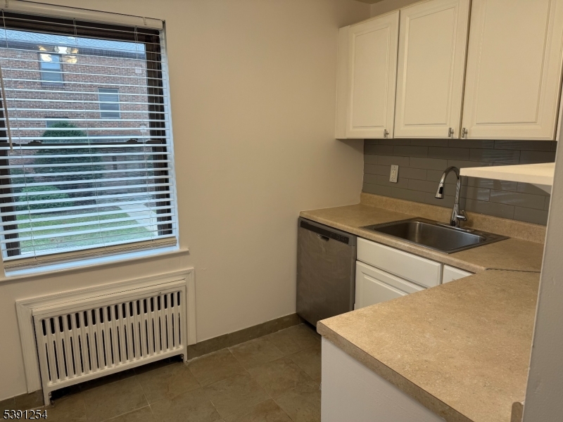 799 Mountain Avenue, Unit D Springfield, NJ 07081 - Photo 10 of 16 a kitchen with granite countertop white cabinets and sink