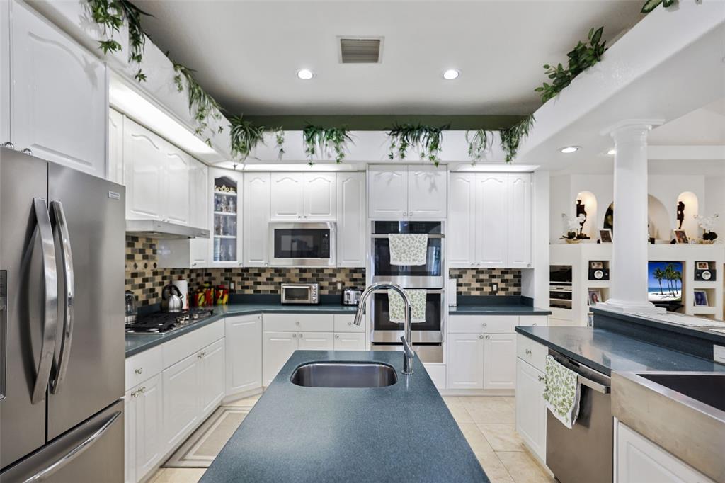 14423 Kandi Court Largo, FL 33774 - Photo 13 of 75 a kitchen with stainless steel appliances a refrigerator a sink a stove and white cabinets