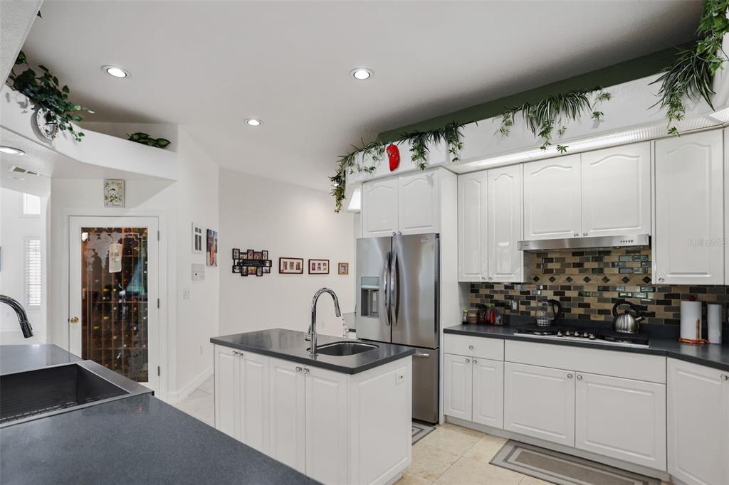 14423 Kandi Court Largo, FL 33774 - Photo 16 of 75 a kitchen with stainless steel appliances kitchen island granite countertop a refrigerator and a sink