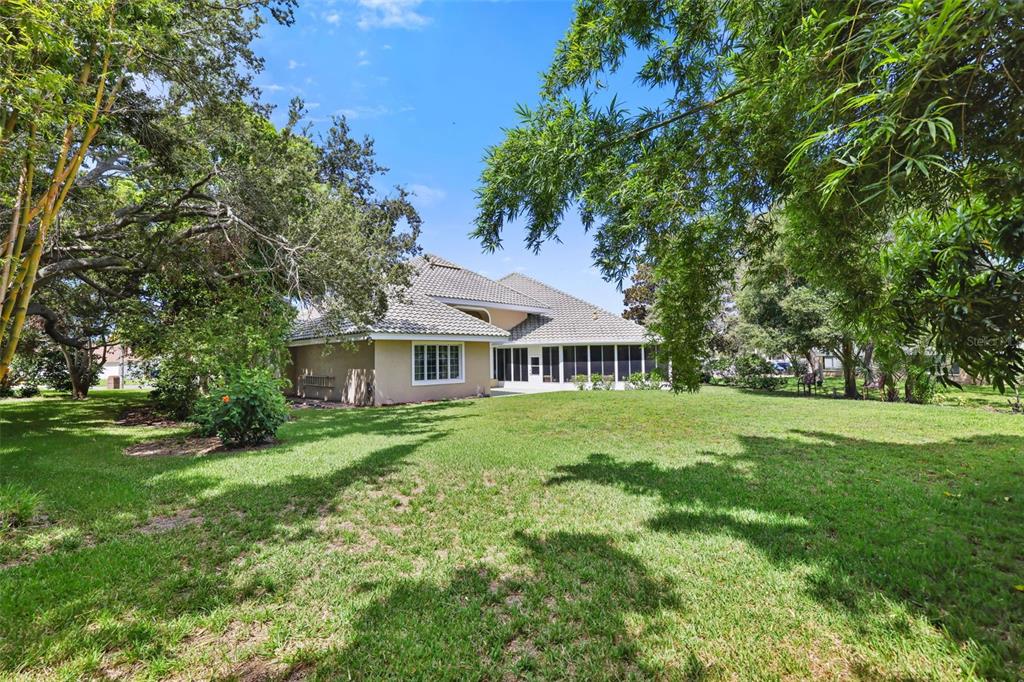 14423 Kandi Court Largo, FL 33774 - Photo 59 of 75 a view of a house with a big yard potted plants and large tree