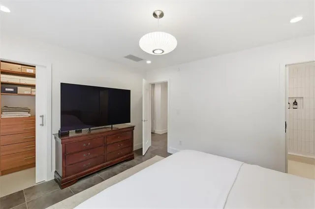 a bedroom with a bed and a flat screen tv
