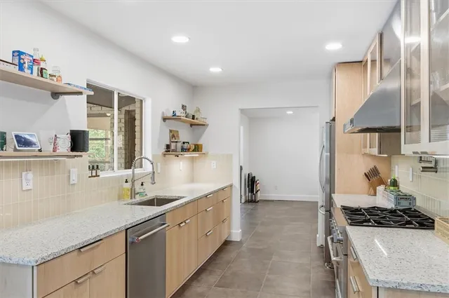 a kitchen that has a lot of cabinets in it and wooden floors