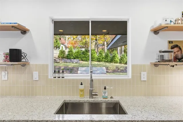 a kitchen that has a sink a stove and oven