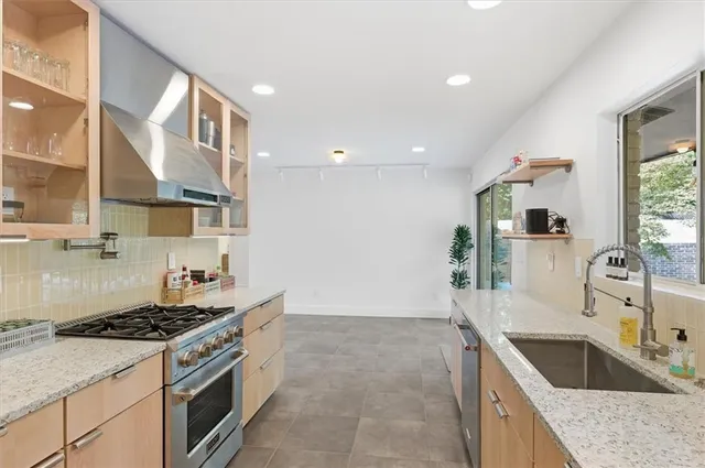 a kitchen with stainless steel appliances granite countertop a stove and a sink