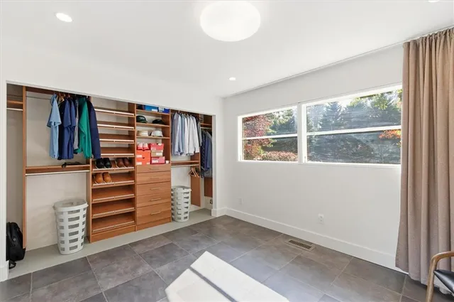 a view of walk in closet with clothes and shoes
