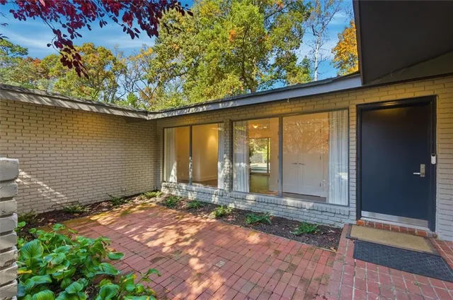 a view of a house with a yard and large tree