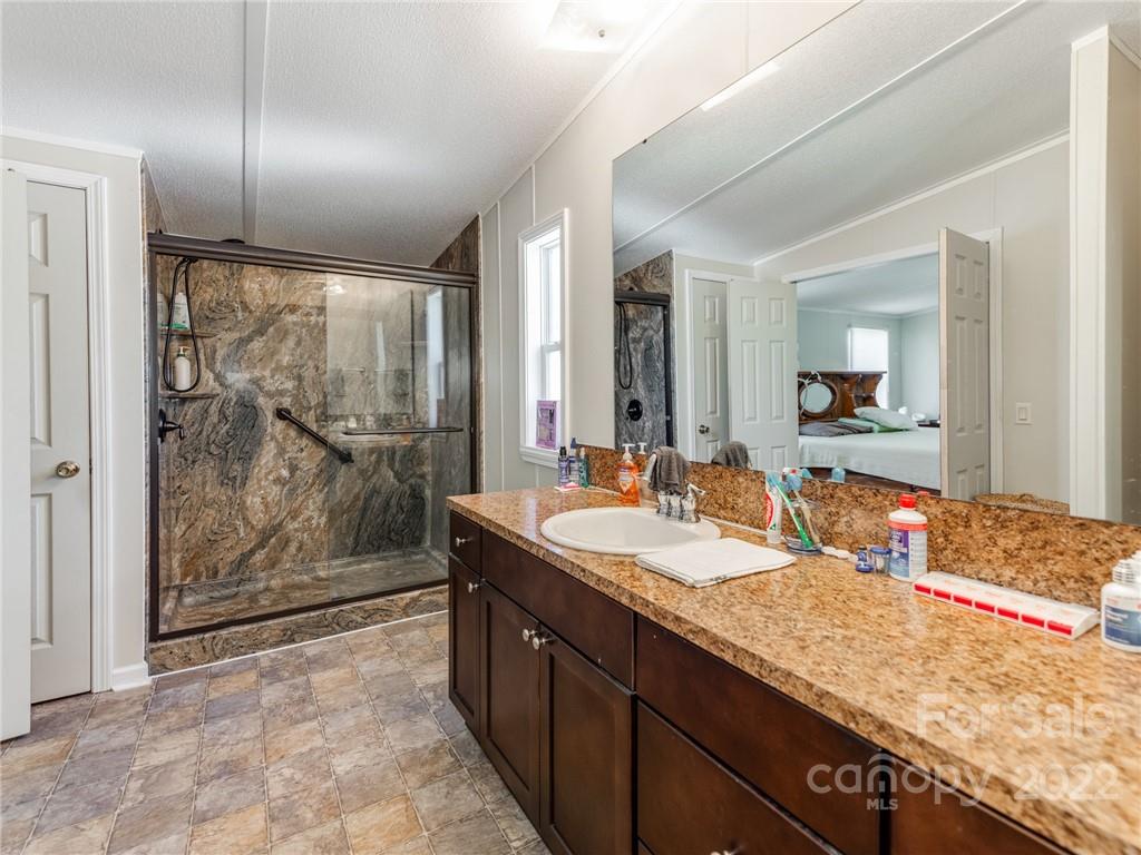 3402 Griffith Road Monroe, NC 28112 - Photo 15 of 28 a spacious bathroom with a granite countertop sink mirror and shower