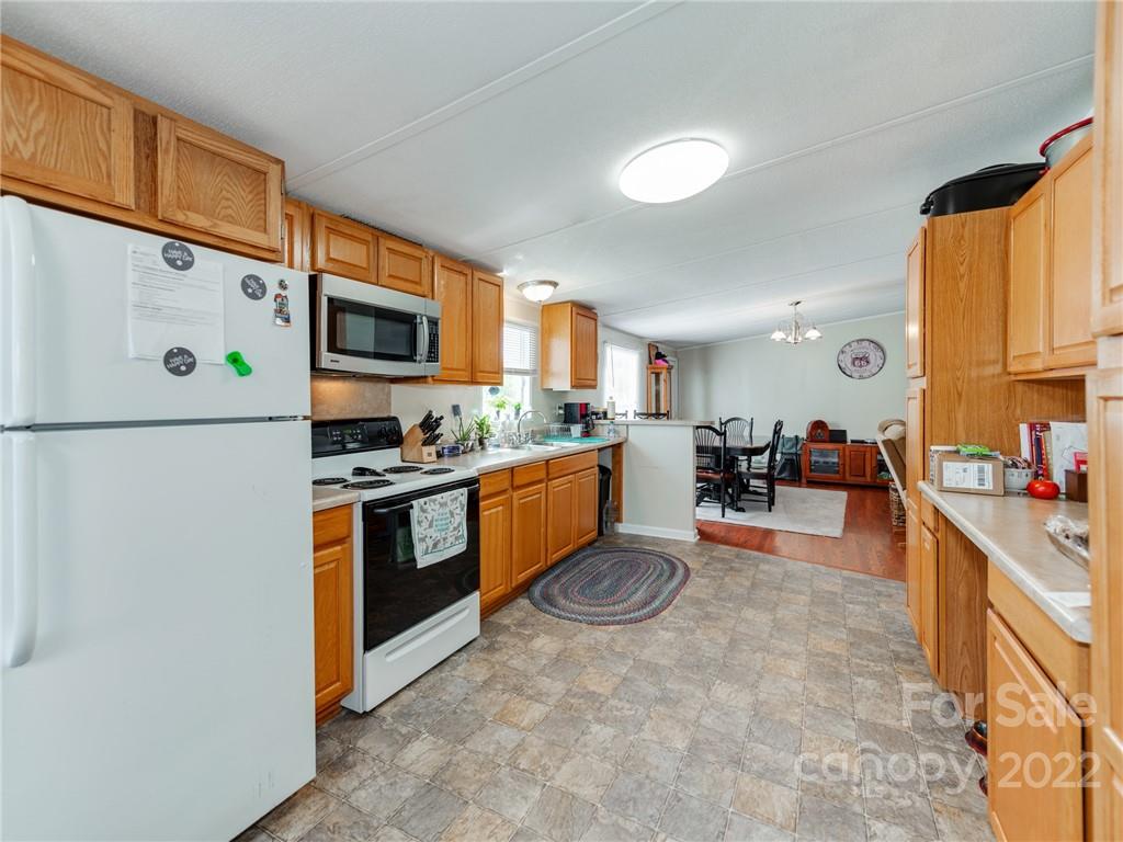 3402 Griffith Road Monroe, NC 28112 - Photo 10 of 28 a kitchen with stainless steel appliances granite countertop a refrigerator a stove a sink a dining table and chairs with wooden floor