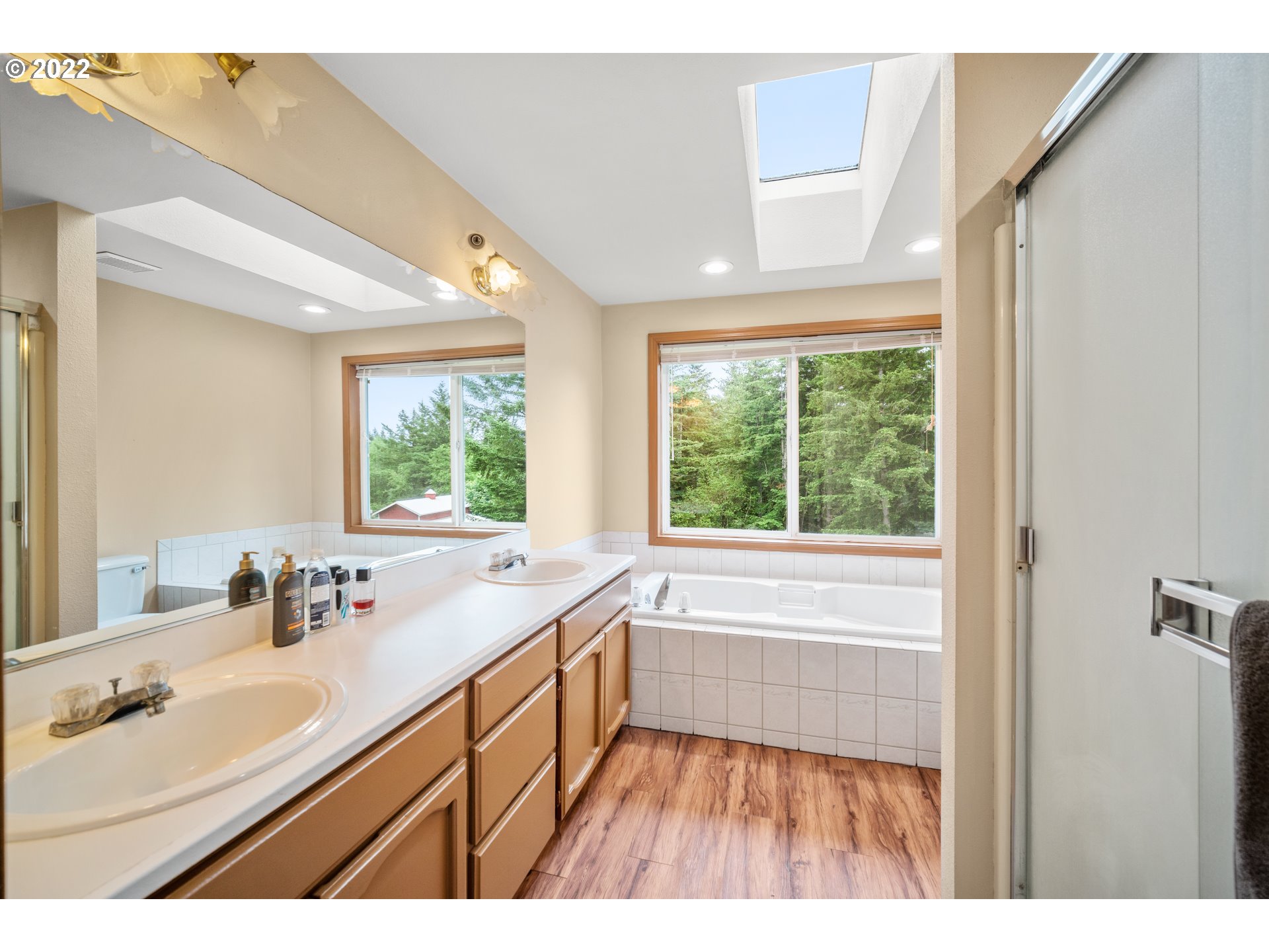 16207 Northeast Beebe Road Battle Ground, WA 98604 - Photo 23 of 32 a bathroom with a sink a large mirror and a bathtub next to a window