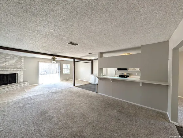 a view of empty room with a fireplace and windows