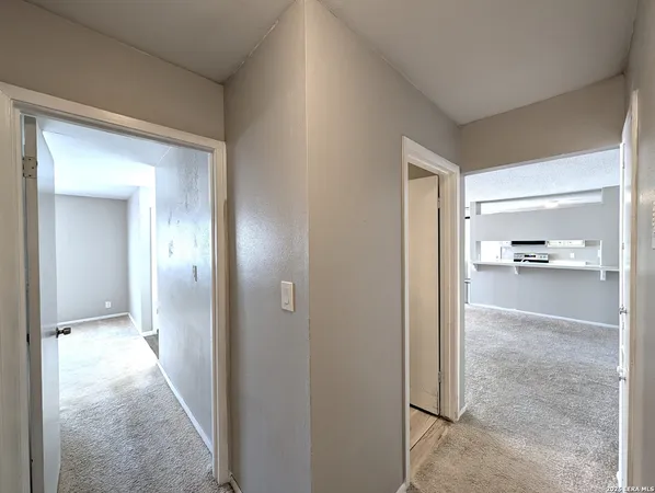 a view of a hallway with wooden floor and a living room